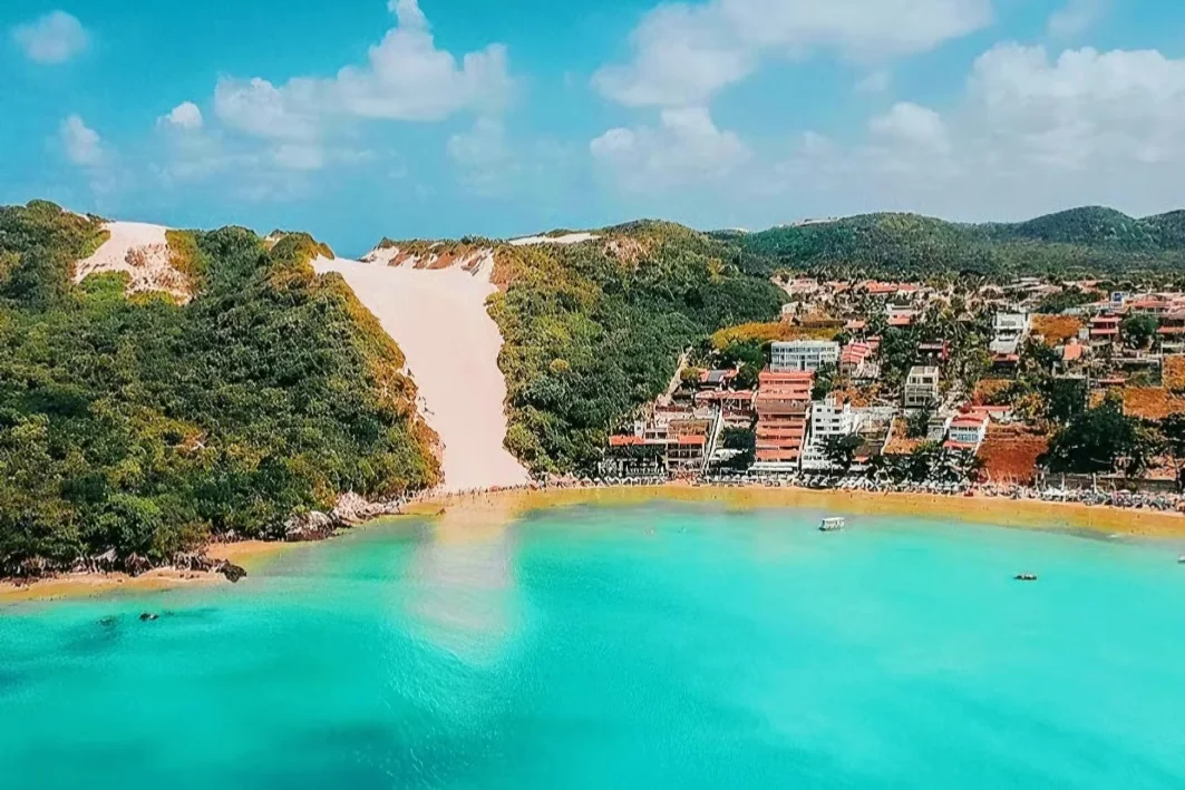 Morro do Careca e a praia de Ponta Negra em Natal, com o mar azul-turquesa e as casas na encosta