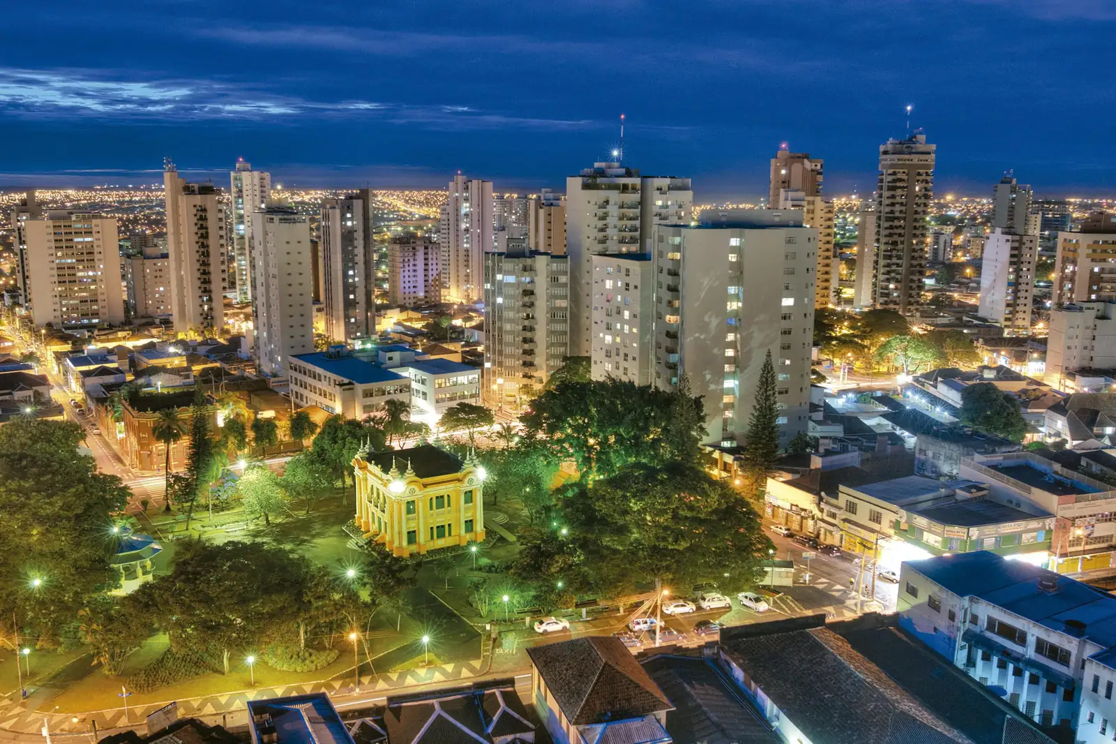 Praça Tubal Vilela iluminada à noite, no centro de Uberlândia, com os prédios da cidade ao redor